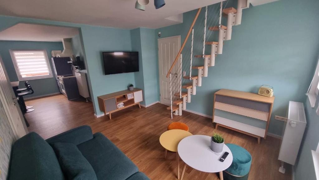 uma sala de estar com um sofá, uma mesa e escadas em Haus Erdmann em Dahn