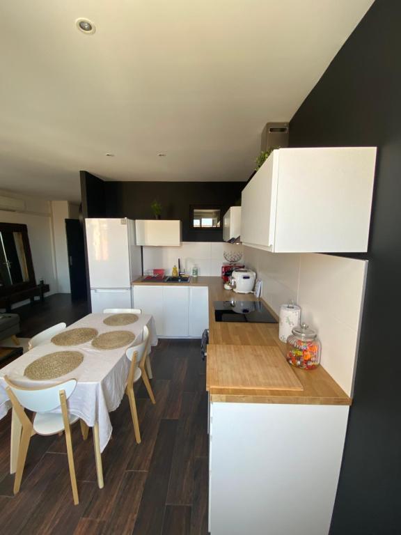 a kitchen with a table and some white cabinets at Lumineux T3 avec vue Mer dans le Centre Historique in Sainte-Maxime