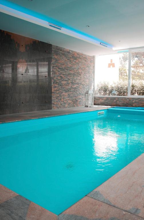 a swimming pool with blue water in a house at Principe Alogna Hotel & SPA in Altavilla Milicia
