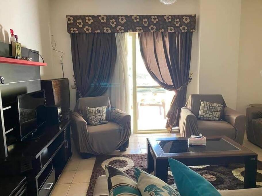 Chalet in Stella Marina, El Alamein في العلمين: غرفة معيشة مع أريكة وكراسي ونافذة