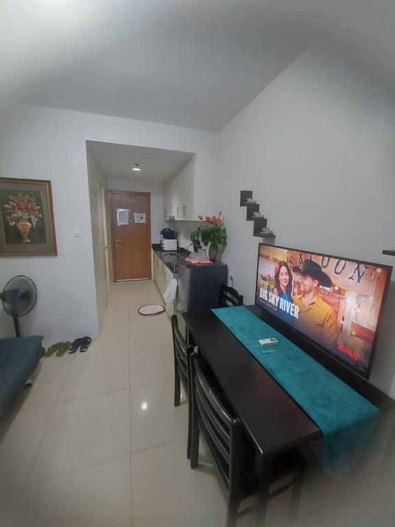 a living room with a large tv on the wall at Cozy House in Manila