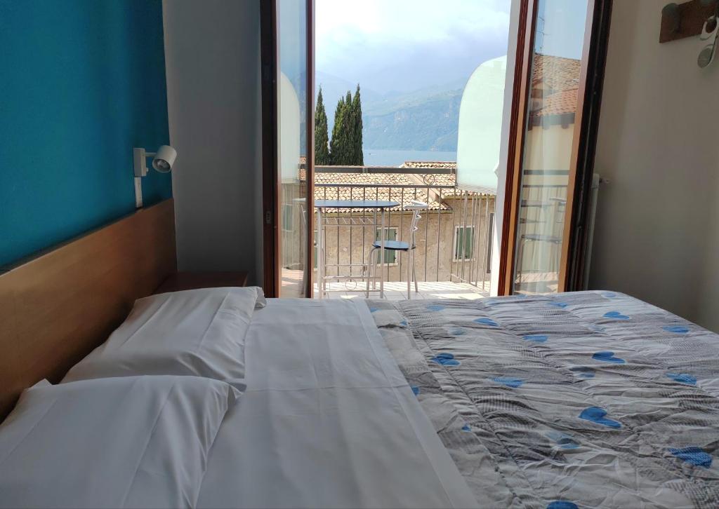 a bedroom with a bed and a window with a view at Hotel Luisa in Brenzone sul Garda