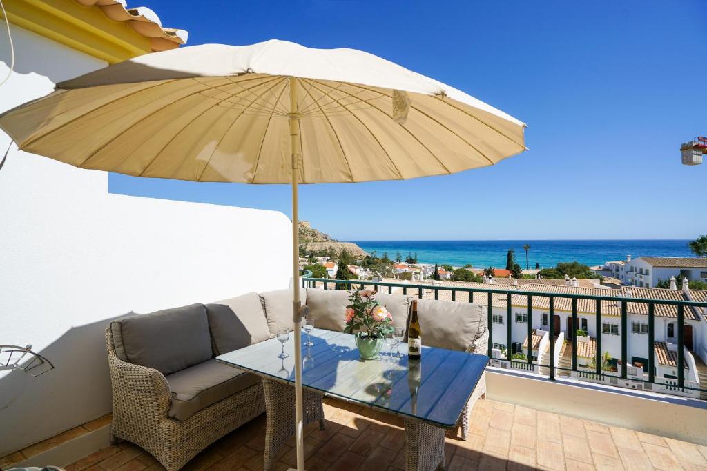 une terrasse avec une table et un parasol dans l'établissement Ramalhete panoramic view apartment, à Luz