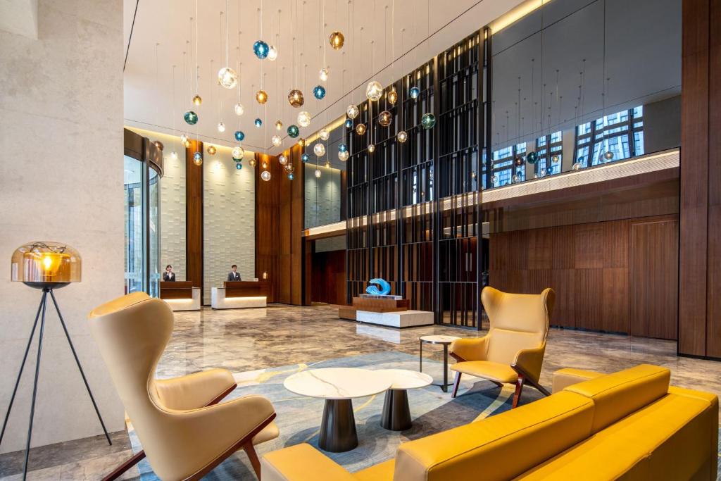 a lobby with a yellow couch and chairs at Fairfield by Marriott Shanghai Hongqiao NECC in Shanghai