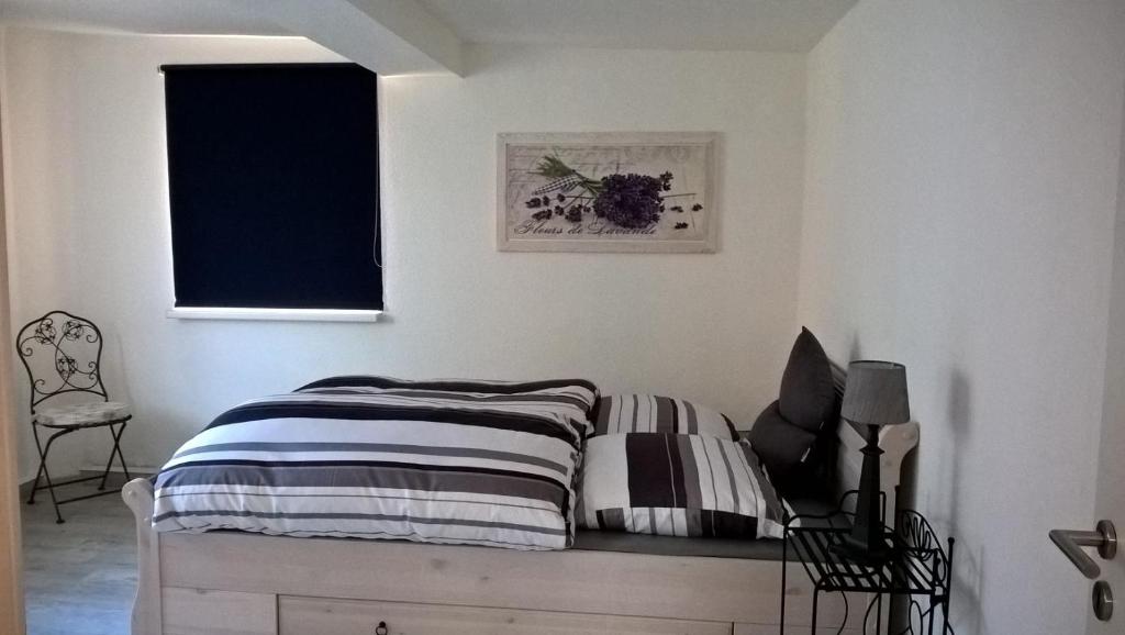 ein Schlafzimmer mit einem Bett und einem Stuhl in der Unterkunft Wohnung Nähe Uni Ilmenau und Autobahn A71 in Ilmenau