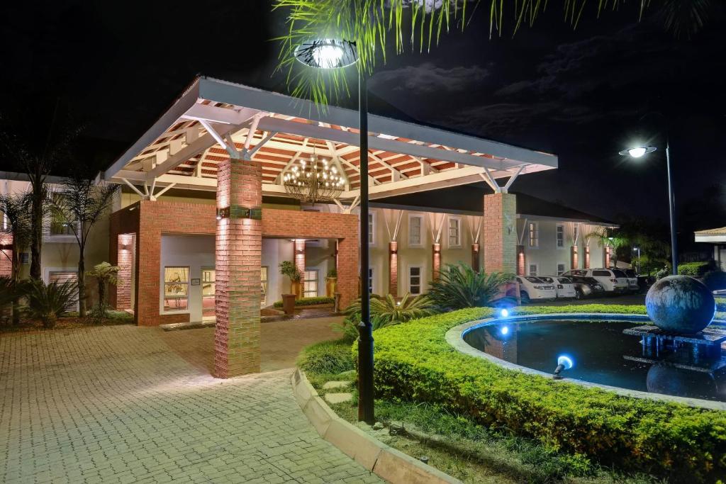 a house with a swimming pool at night at Protea Hotel by Marriott Nelspruit in Nelspruit