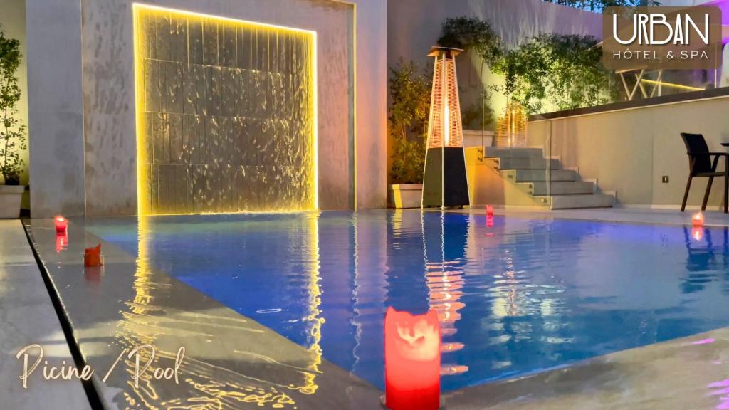 uma piscina com uma vela vermelha em frente a uma fonte em Urban Hotel & Spa em Kenitra