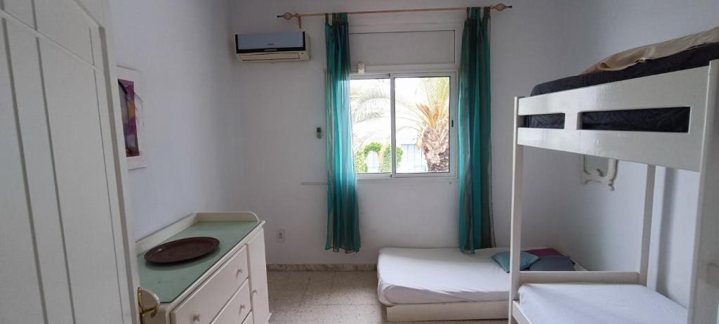 - une chambre avec des lits superposés et une fenêtre dans l'établissement Résidence meriem 2, à Hammamet