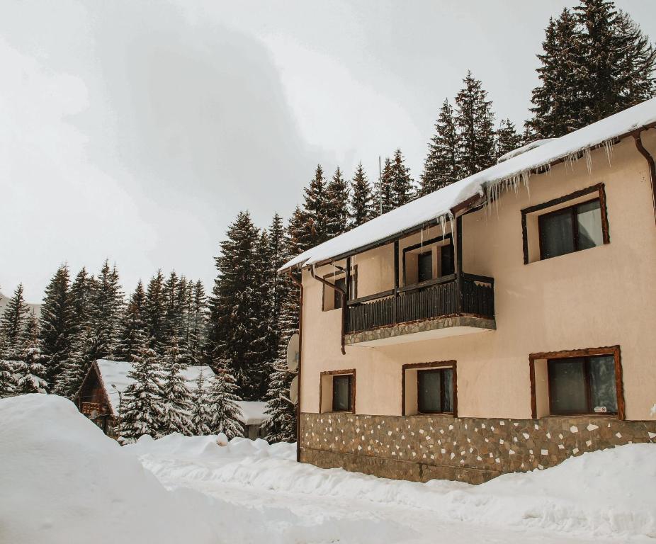 um edifício coberto de neve com árvores ao fundo em MountHoff Retreat em Moroeni