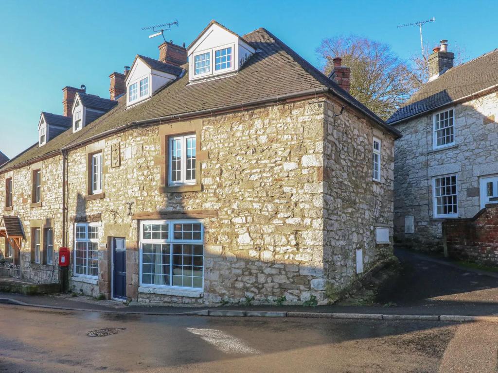 an old stone house on the side of a street at Lovely 4 bed house sleeping 8 near Ashbourne in Brassington
