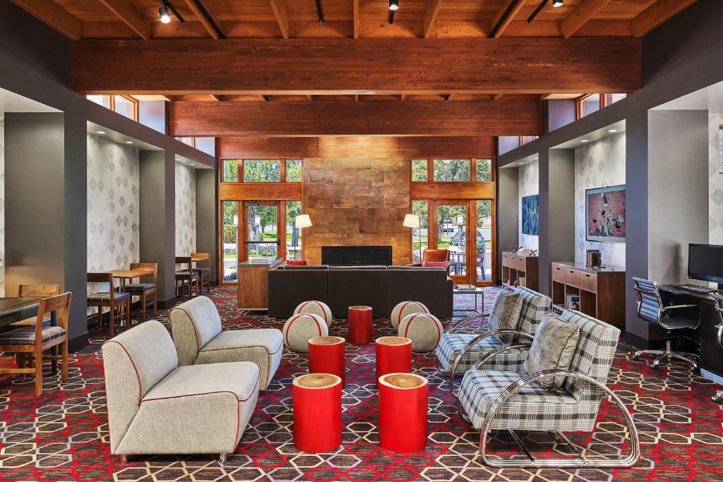 a lobby with chairs and a table and a piano at Four Points Marriott Salt Lake City Airport in Salt Lake City