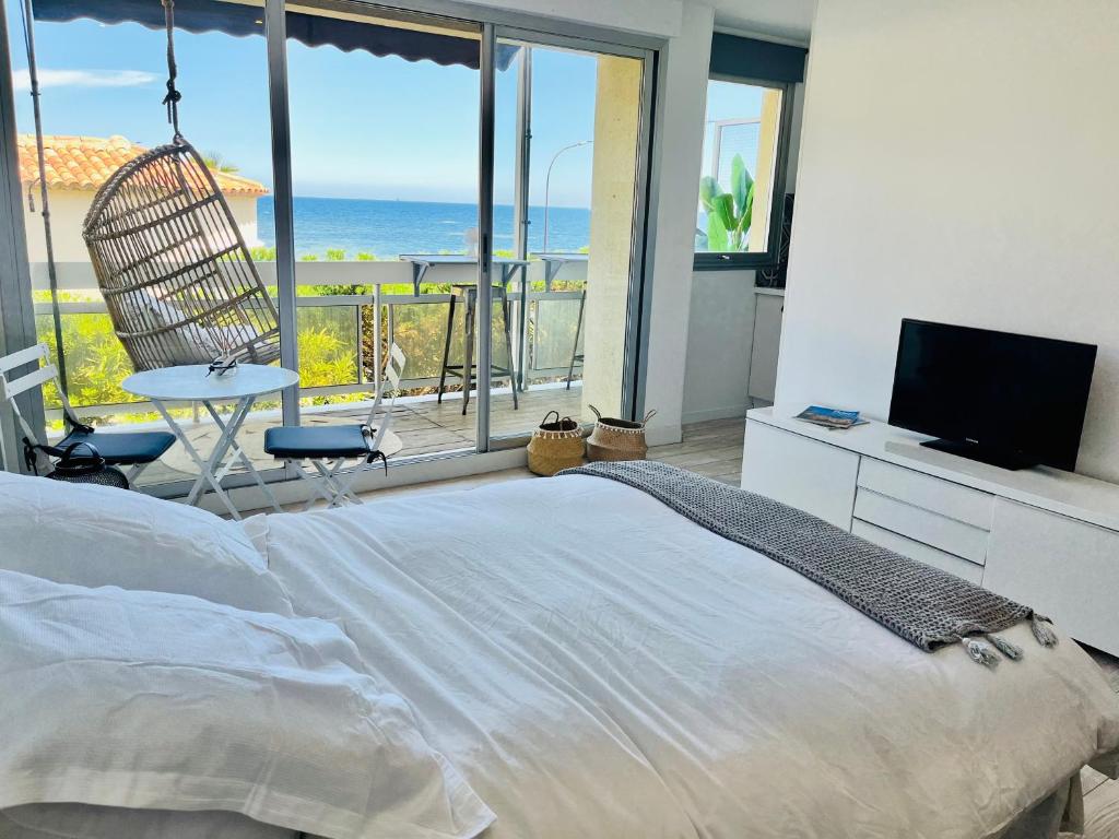 een slaapkamer met een bed en uitzicht op de oceaan bij Charmant studio avec terrasse vue mer à 50 m in Sainte-Maxime