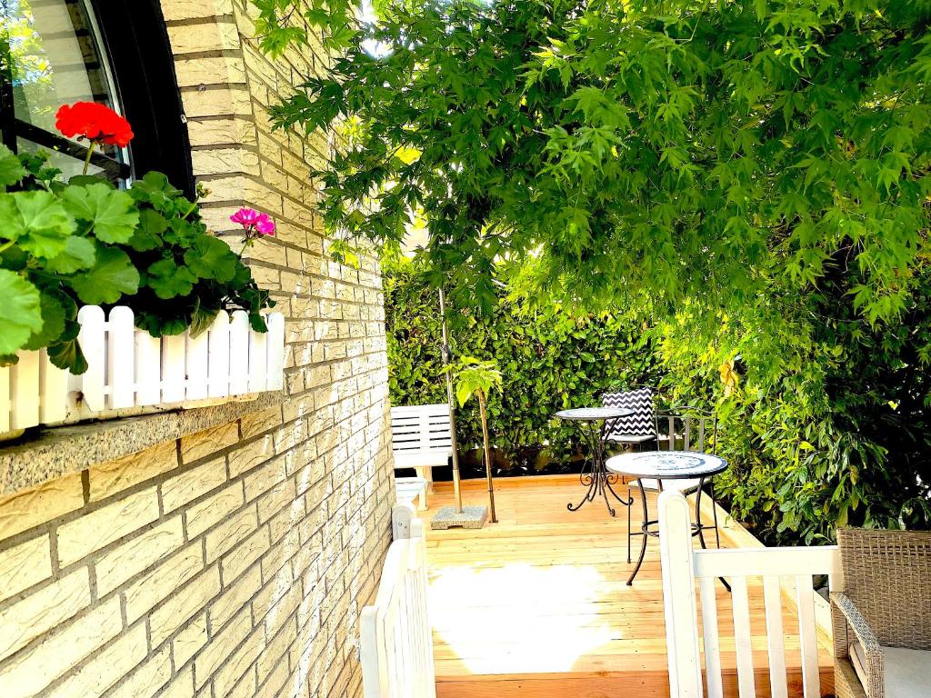 a patio with a table and chairs and a brick wall at VILLA ORCHARD Frankfurt in Zeilsheim