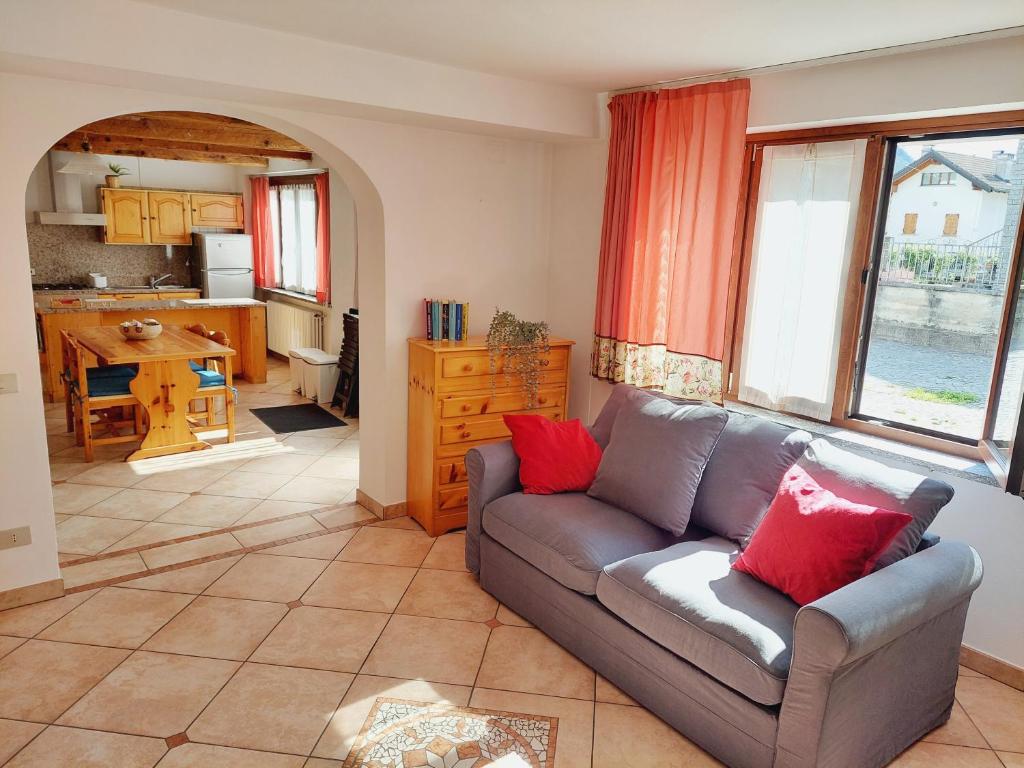 a living room with a couch and a kitchen at Casa Pepolina, zona tranquilla, piano terra con parcheggio in Malesco