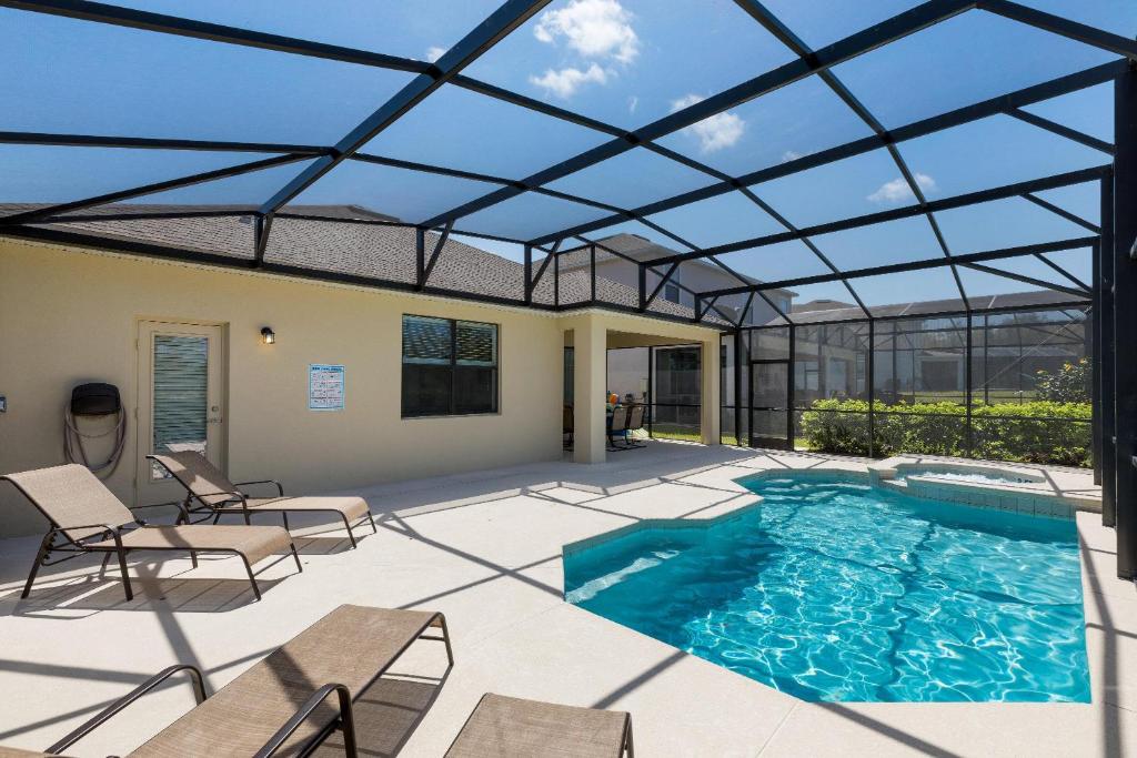 a patio with a pool and a glass ceiling at South Facing Vacation Home - Providence Golf Resort - Pool & Spa - Game Room - Free Welcome Pack in Loughman