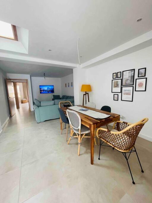 a living room with a wooden table and chairs at Attic apartment in old town in Denia