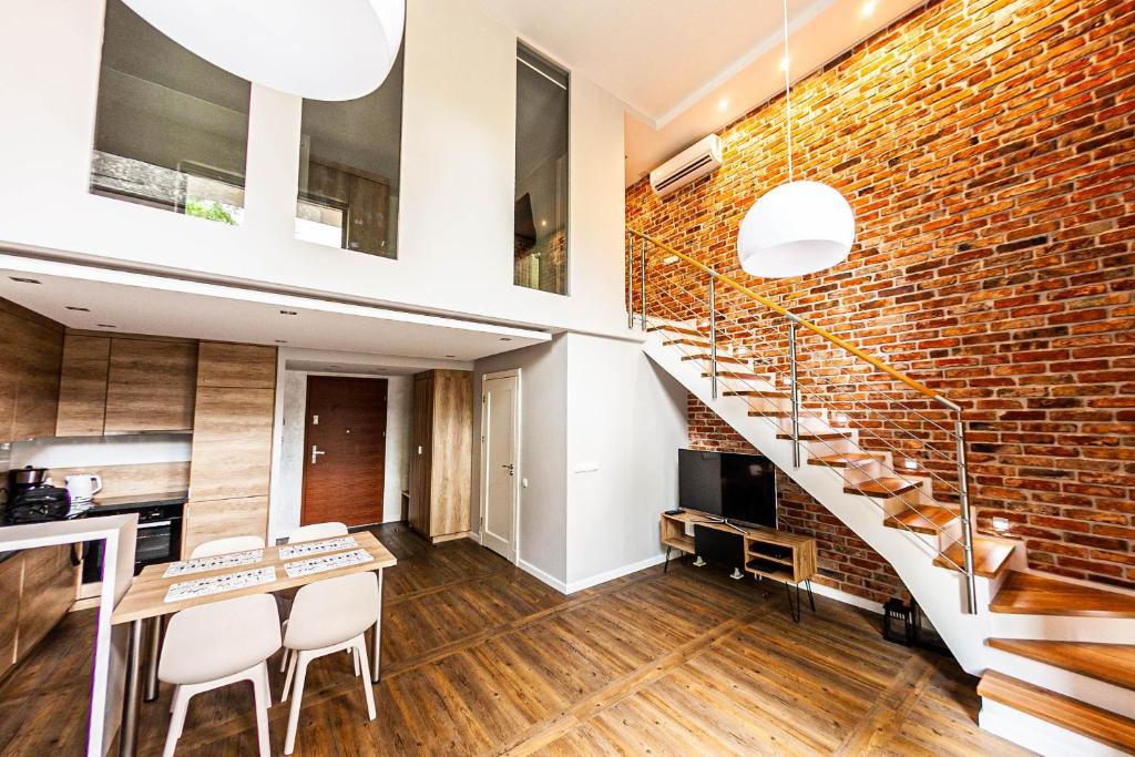 a brick wall and stairs in a kitchen and dining room at Euro Apartments Szafarnia Delux in Gdańsk