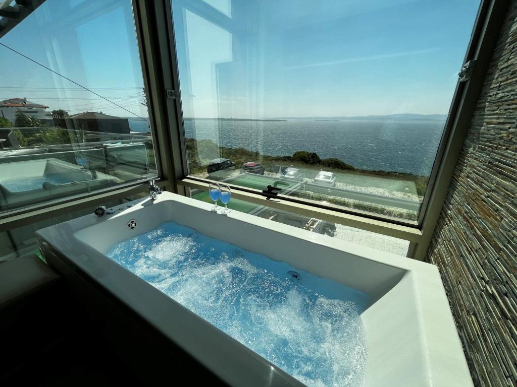 a bath tub in a room with a window at Mavi Panorama Villa in Çeşme