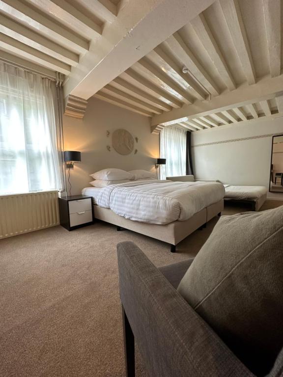 a large bedroom with a bed and a couch at Hotel Grand Canal in Delft