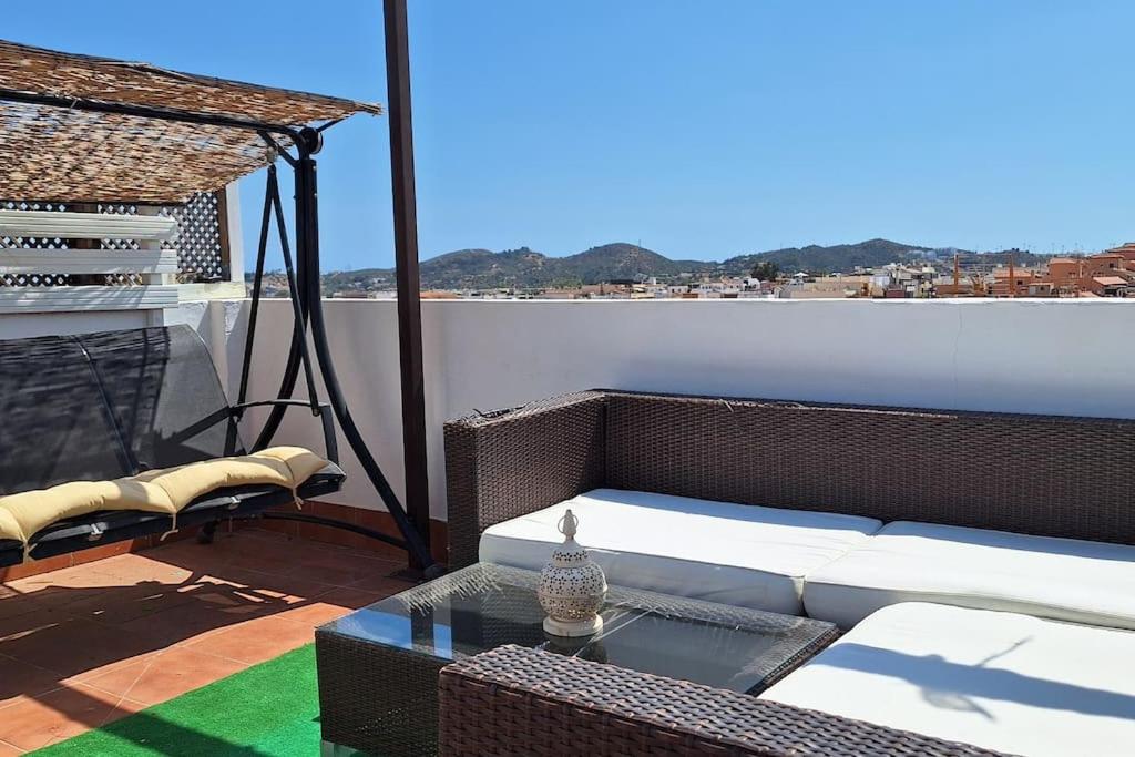 a living room with a couch and a table on a balcony at The 2 bed-Roof terrace-apartment in Málaga