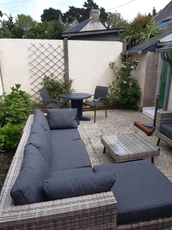 eine Terrasse mit einem Sofa, einem Tisch und Stühlen in der Unterkunft Maison de paludier in Guérande