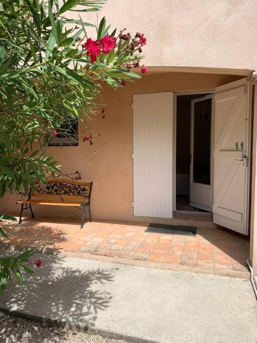une entrée d'un bâtiment avec un banc dans une cour dans l'établissement Studio en rez-de-jardin arboré avec accès piscine et clim, à Villeneuve-lès-Avignon