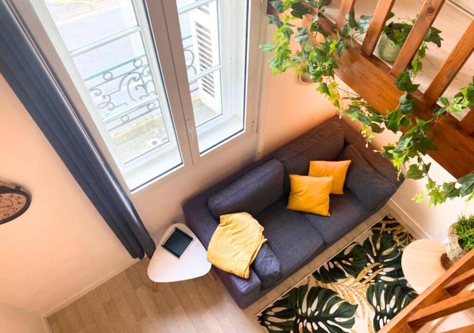 - une vue de tête sur un canapé dans une chambre dotée d'une fenêtre dans l'établissement Le Sainte-Croix - Poitiers Centre - La Conciergerie., à Poitiers