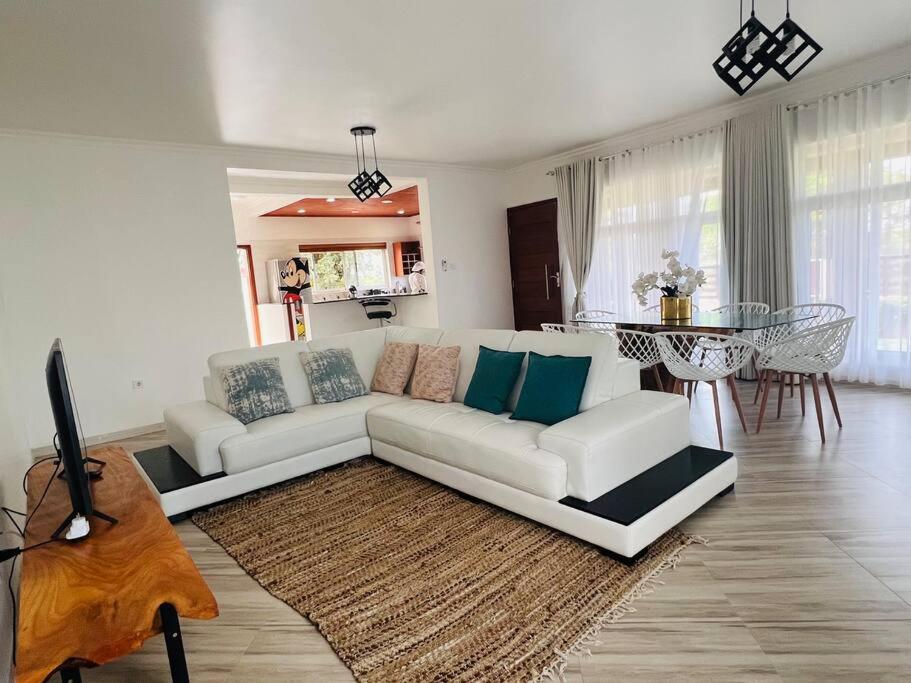 a living room with a white couch and a table at Casa Conforto Bilene in Vila Praia Do Bilene