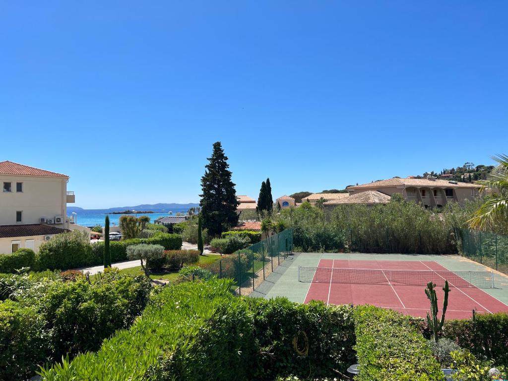 a tennis court in the middle of a garden at L'Appartement des Sables in Le Lavandou