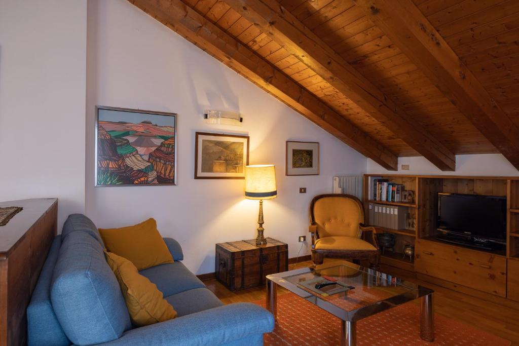 a living room with a blue couch and a tv at Casa Marmarole in Borca di Cadore