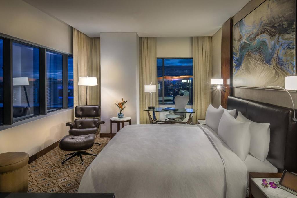 a hotel room with a large bed and a chair at JW Marriott Hotel Santo Domingo in Santo Domingo