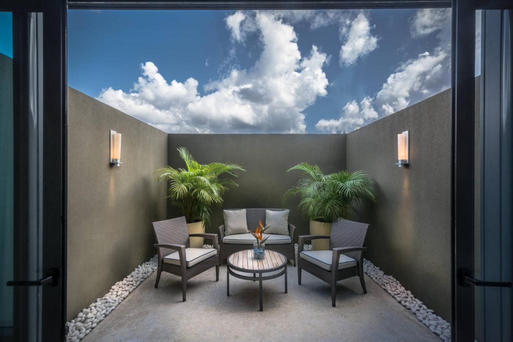 a patio with palm trees and a table and chairs at JW Marriott Hotel Santo Domingo in Santo Domingo