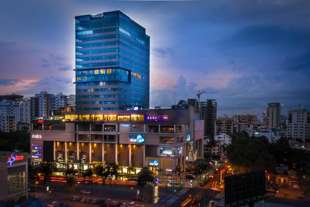 a tall building with lights in front of a city at JW Marriott Hotel Santo Domingo in Santo Domingo
