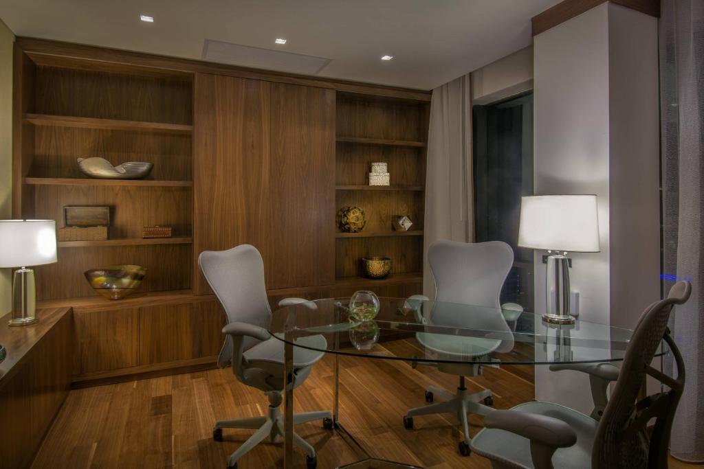 a dining room with a glass table and chairs at JW Marriott Hotel Santo Domingo in Santo Domingo