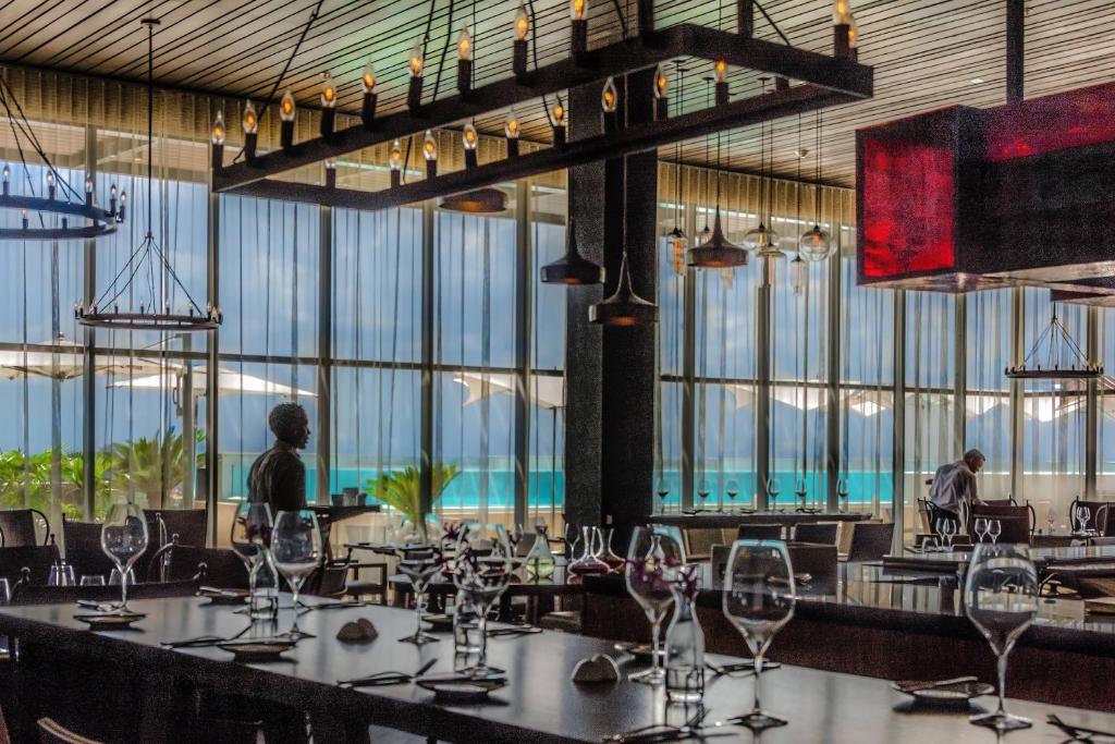 a dining room with tables and chairs and large windows at JW Marriott Hotel Santo Domingo in Santo Domingo