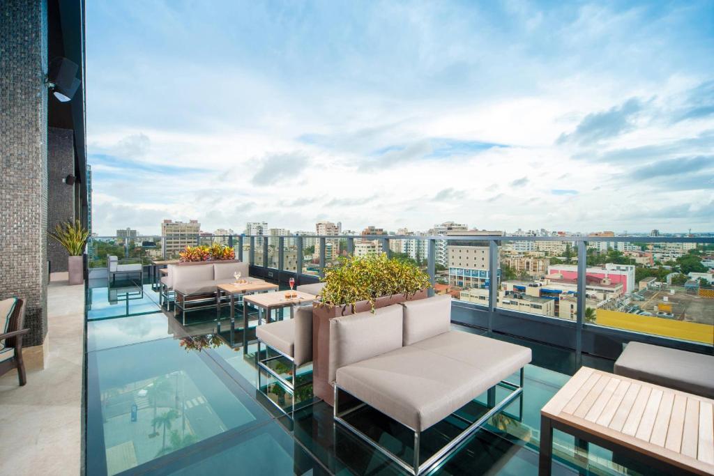 a balcony with chairs and tables and a view of a city at JW Marriott Hotel Santo Domingo in Santo Domingo
