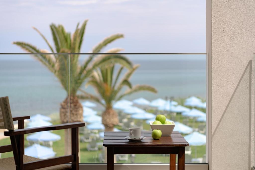 a table with a bowl of fruit on top of a balcony at Creta Royal - Adults Only in Skaleta