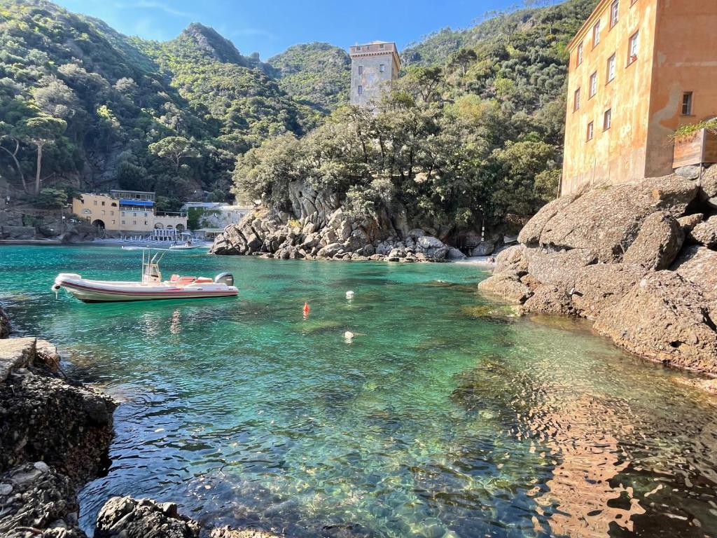 a boat in the water next to a mountain at Casa dell'Arco Civico 35 in San Fruttuoso