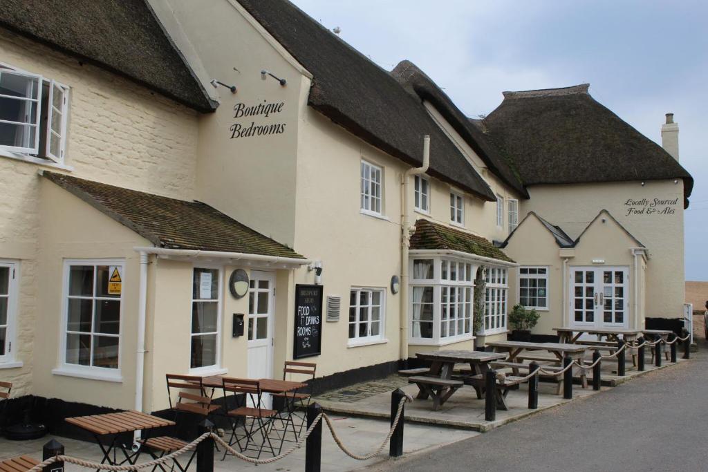 a group of tables and benches in front of a building at Bridport Arms Hotel in West Bay