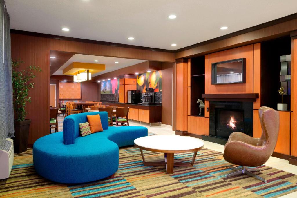sala de estar con muebles azules y chimenea en Fairfield Inn & Suites Minneapolis St. Paul/Roseville en Roseville