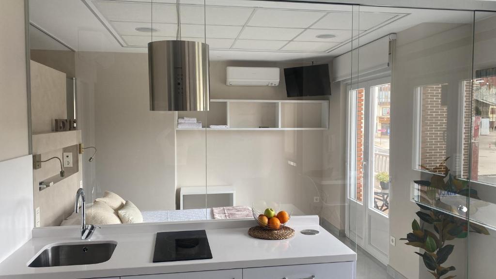 a kitchen with a sink and a bowl of fruit on a counter at Astorga suites in Astorga