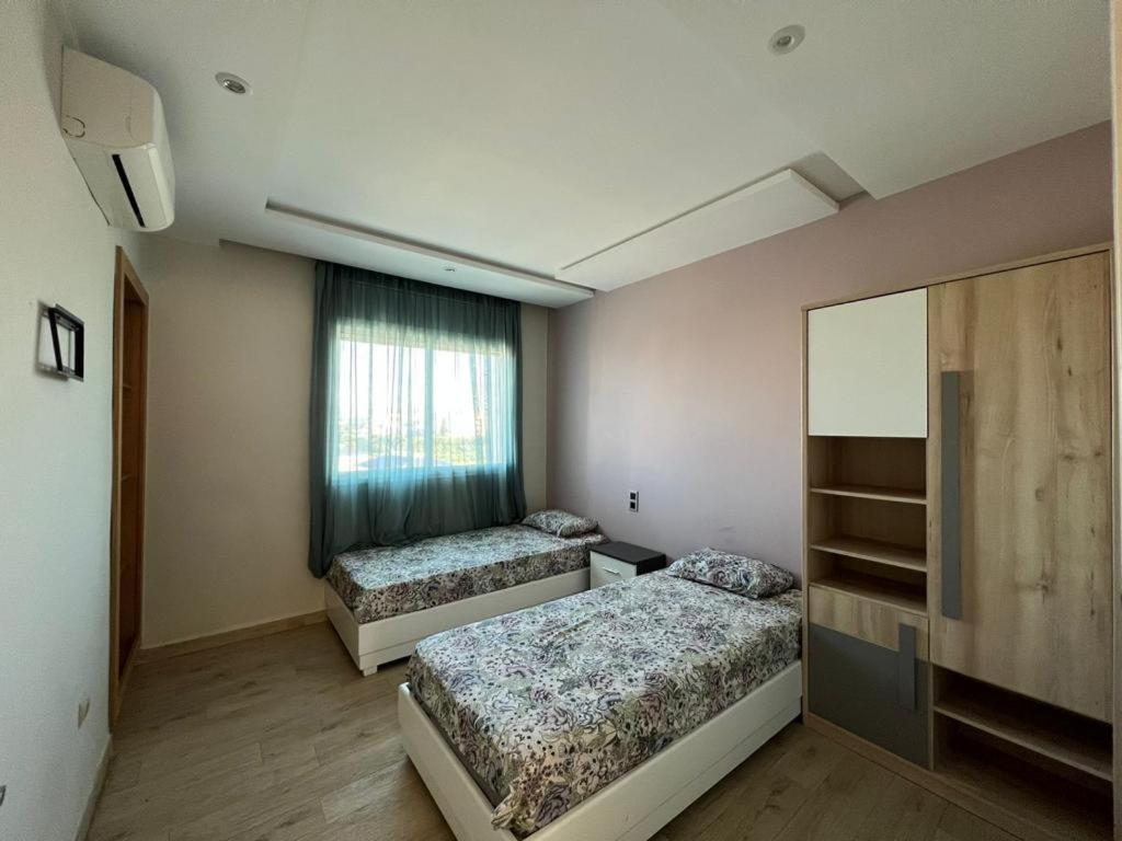 a bedroom with two beds and a window at Casa Marina Smir in Marina Smir