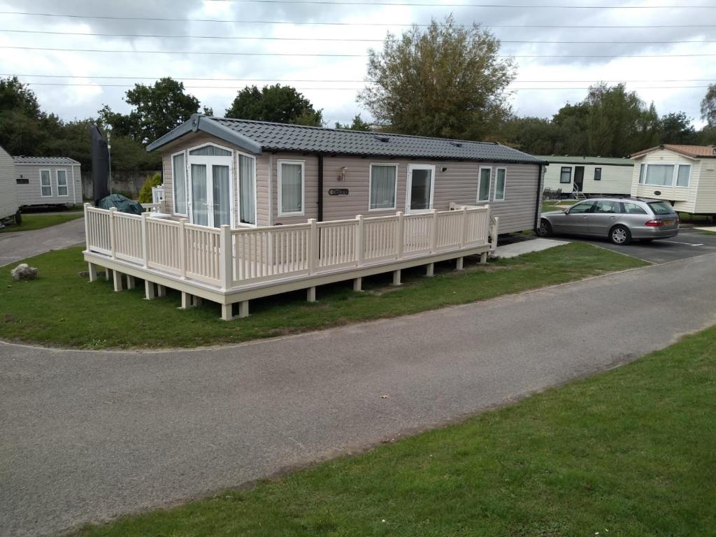 a mobile home with a porch on the side of a road at Rockley Park, The Poplars in Lytchett Minster