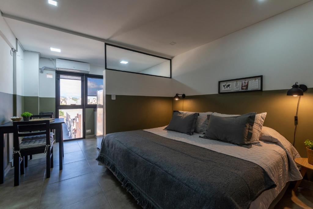 um quarto com uma cama, uma secretária e uma janela em Departamento céntrico II con estacionamiento gratis em San Salvador de Jujuy