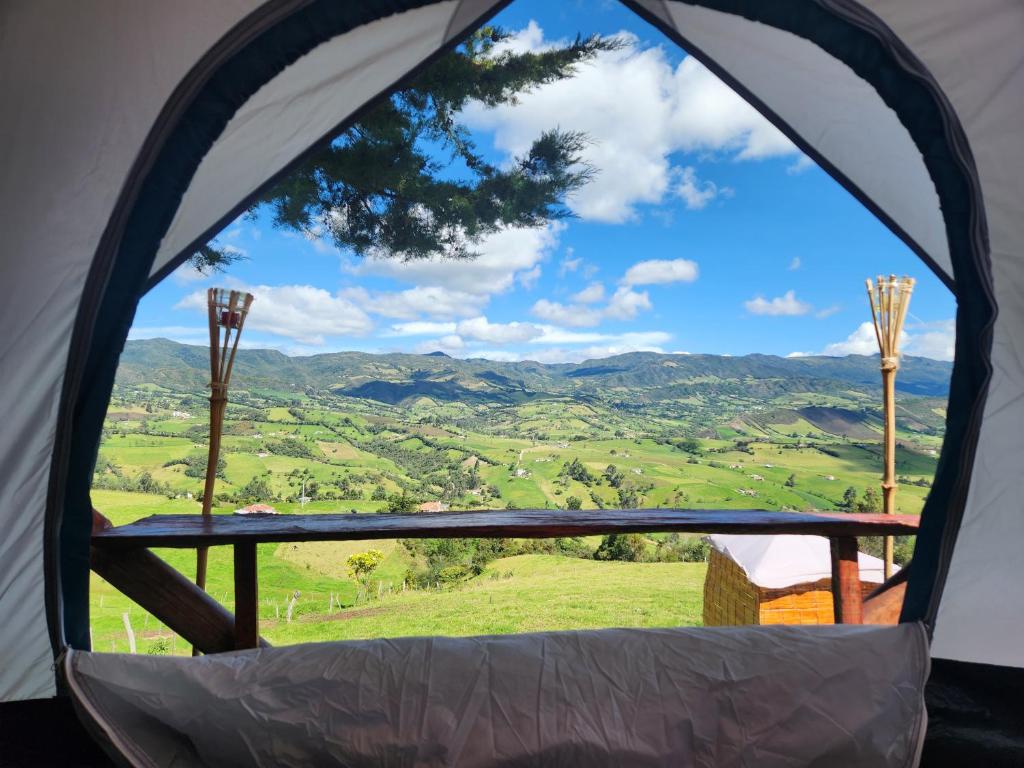 una vista desde el interior de una tienda con vistas a las montañas en Carpe Diem, en Guatavita