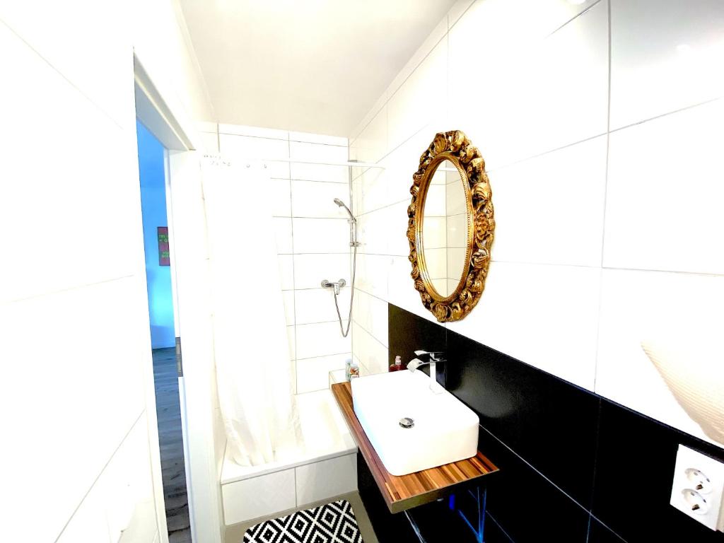 a bathroom with a sink and a mirror at VILLA ORCHARD Frankfurt in Zeilsheim