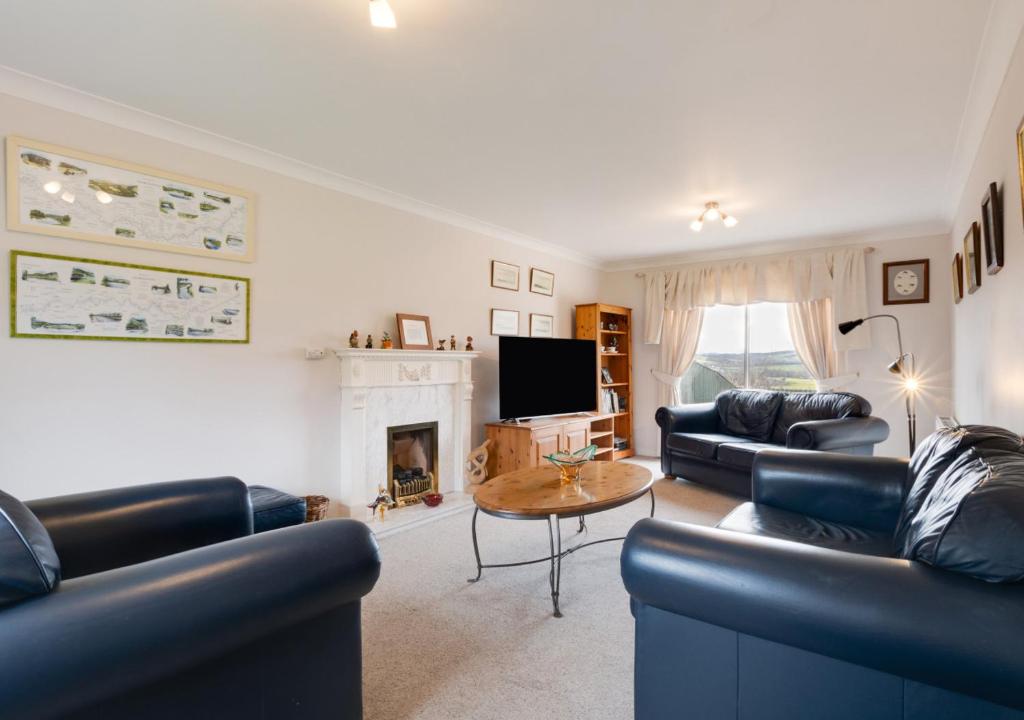 a living room with leather couches and a fireplace at Bishops Hill in Acomb