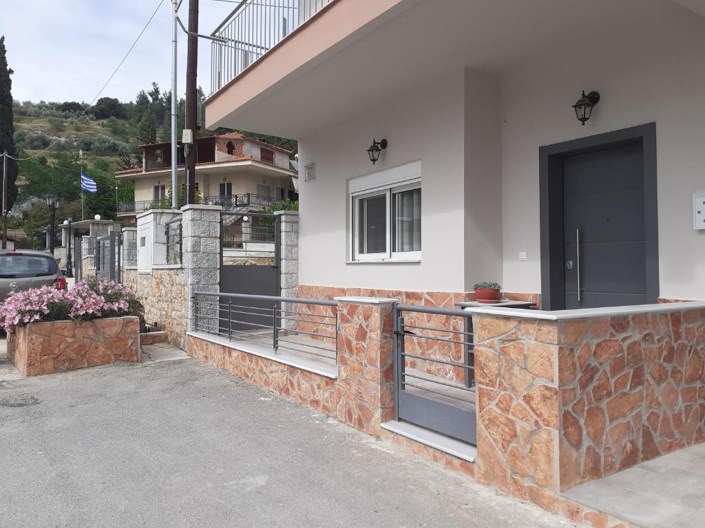 una casa con un balcón con una puerta. en Vagelis Nemea apartments, en Neméa