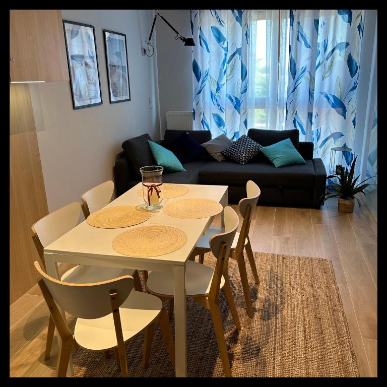 uma mesa branca e cadeiras numa sala de estar em Apartament Walizka em Gdansk