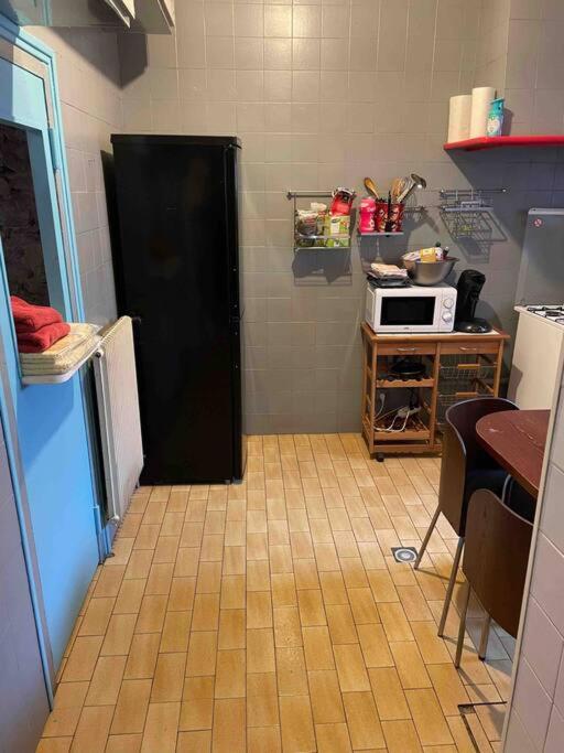 a small kitchen with a black refrigerator and a table at Chez dada in Grenoble